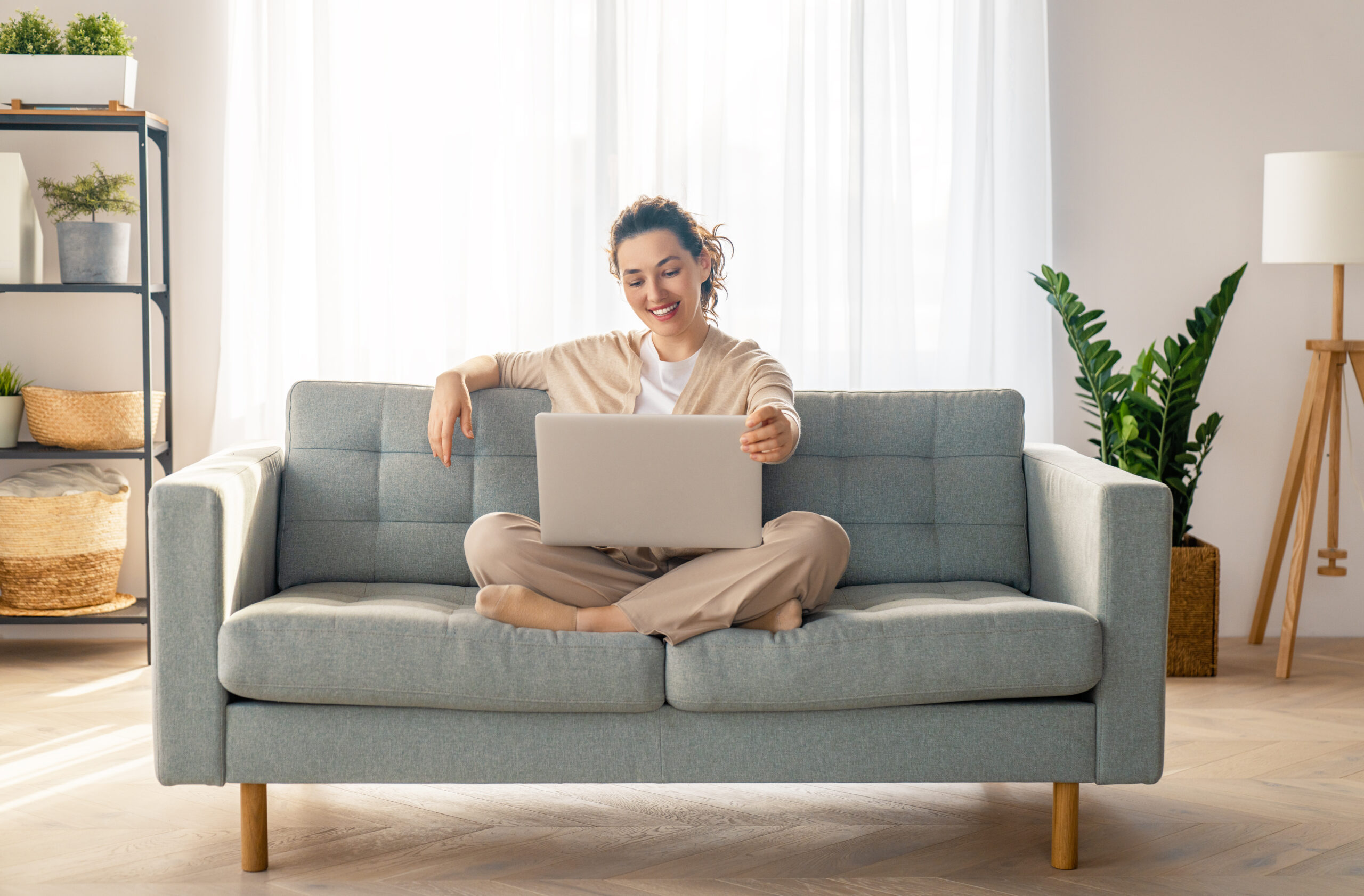 Woman on couch holding laptop